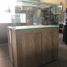 Large glass aquarium with wooden base in a room setting