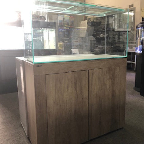 Large glass aquarium with wooden base in a room setting